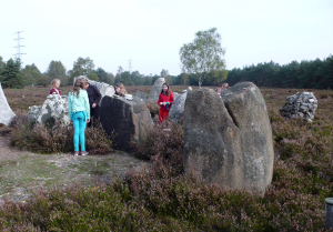 Kinderen van het Colourful City Kinderkoor tussen de stenen van het Monument voor het Onbekende Kind.